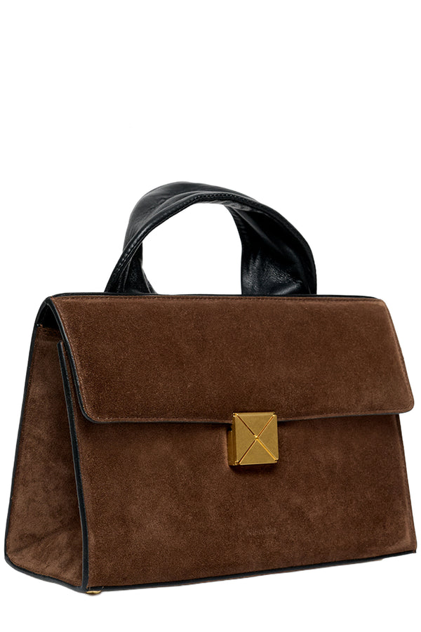 A brown suede handbag with a black leather top handle and trim, featuring a gold-tone pyramid-shaped metal clasp on the front flap.