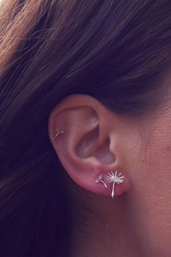 Model wearing the Asymmetric Dandeloin fluff stud earrings in gold colour from the brand ALEX MONROE