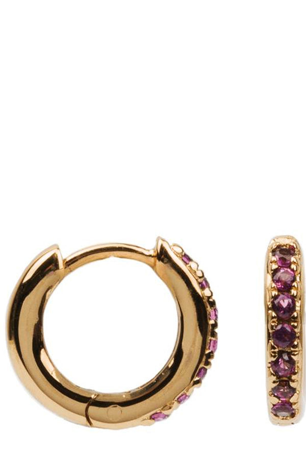 The creole earrings in gold and ruby colour from the brand ALL THE LUCK IN THE WORLD