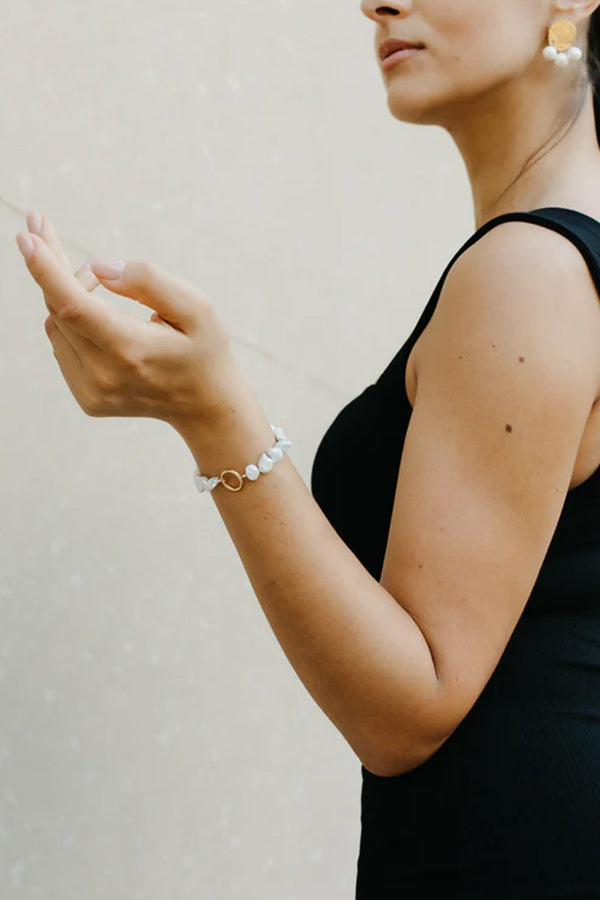 Model wearing the Initial pearl bracelet in gold color from the brand GISEL B.