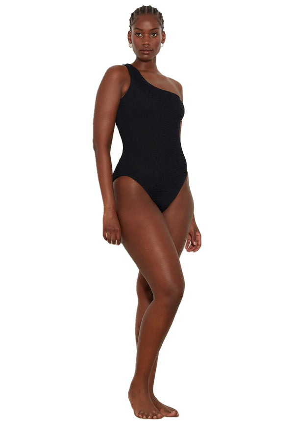 Model wearing the Nancy asymmetric swimsuit in black color from the brand HUNZA G